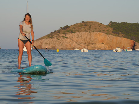 Une femme se tient sur une Planche de paddle en Espagne