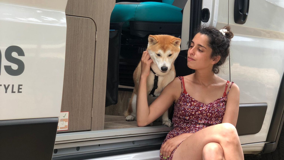 women sitting with her dog in the door of the van
