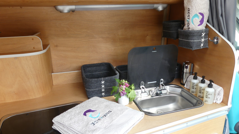 [Translate to Spanish:] Sink and kitchen of the campervan