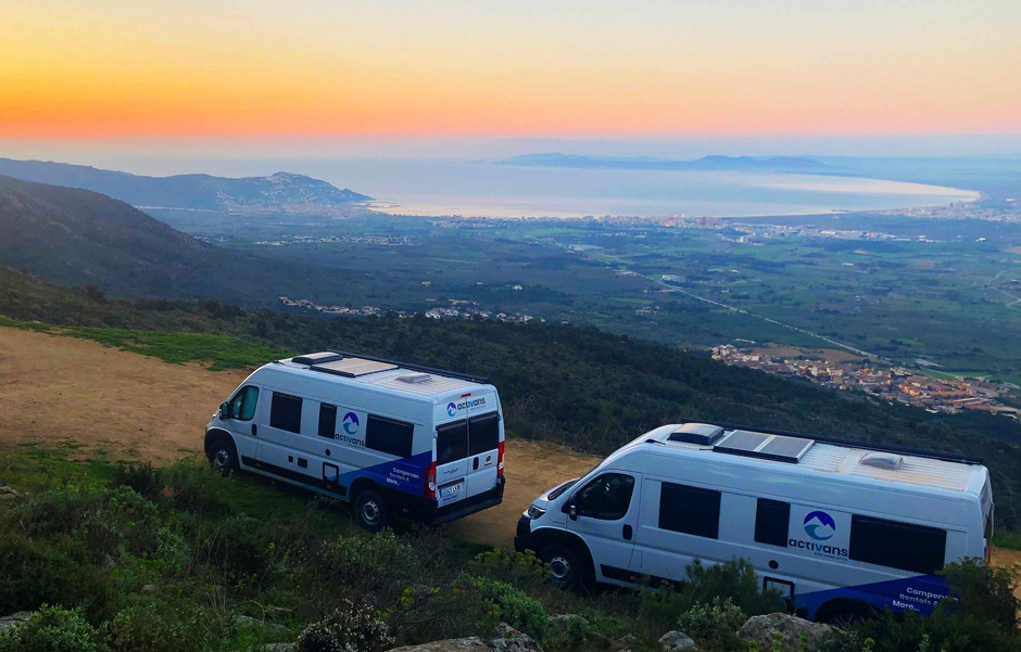 Zwei Campingbusse mit Blick auf die Bucht von Roses bei Sonnenaufang