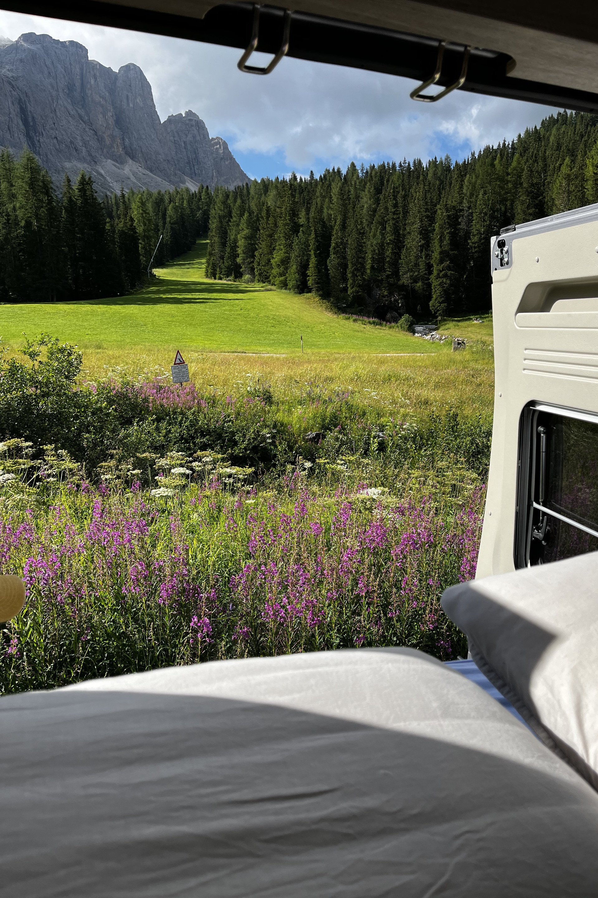 scenic view to the dolomite mountains from the bed of a campervan