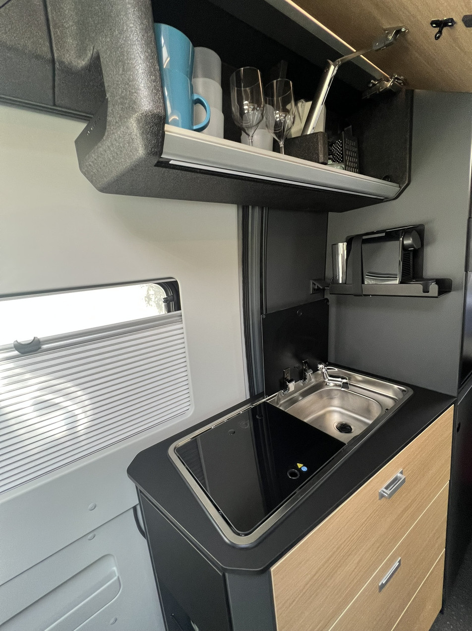 Alquiler autocaravana Barcelona España – cocina con cafetera de cápsulas | Adria Twin 640 SGX | Activans Cocina con almacenamiento y cafetera de cápsulas en autocaravana Adria Twin 640 SGX