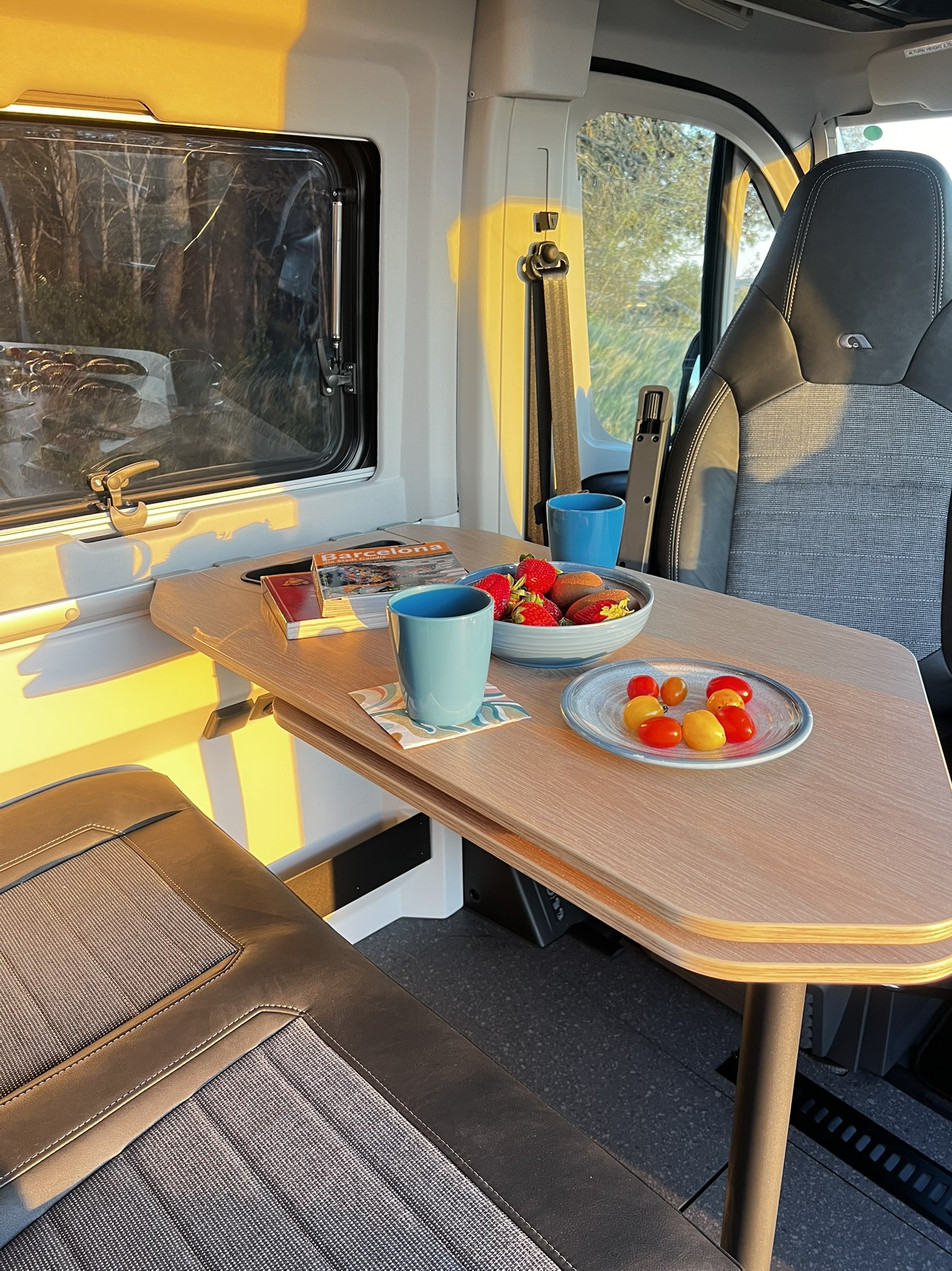 Alquiler camper Costa Brava España – zona comedor | Adria Twin 640 SGX | Activans Mesa con café y snacks en la zona comedor del camper Adria Twin 640 SGX