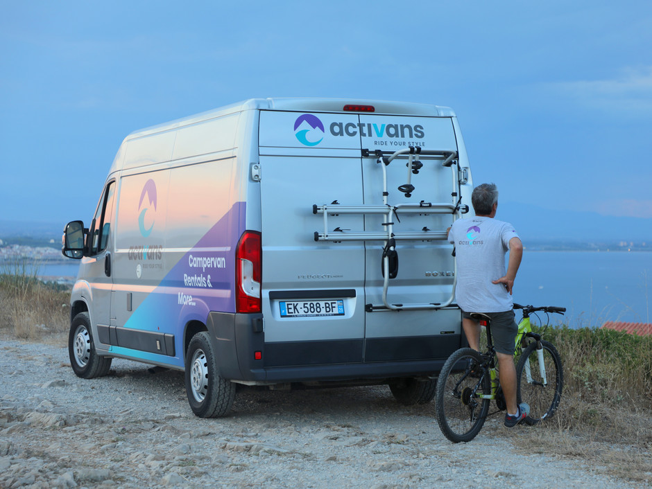 Peugeot Boxer Campervan with Bike Rack on the rear door and a man behind watching the ocean